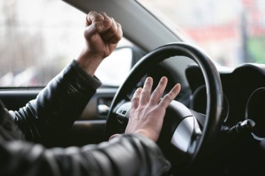 Kızgın sürücü honking olduğunu ve direksiyon simidi oturma tarafından bağırıyor. Yol saldırganlık konsepti. Trafik sıkışıklığı.