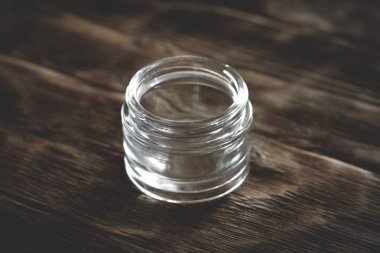 Kahverengi ahşap masa arka plan şeffaf boş bardak krem kavanoz.