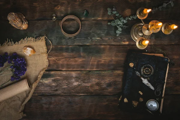 Antik sihirli kitap ve bir cep kopya alanı bir ahşap masa zemin üzerine mum yanan ışığında dikkat et. Büyü kitabı.