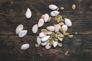 Ahşap masa arka plan üzerinde dağınık kabak çekirdeği.