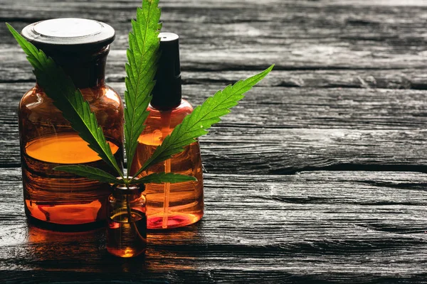 Cannabis Essential Oil Bottle Green Stem Leaves Black Wooden Table — Stock Photo, Image