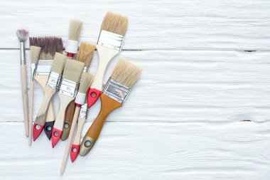 Fotokopi alanı olan beyaz tahta arkaplanındaki boya fırçaları.