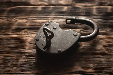 Kahverengi tahta arka planda eski paslı asma kilit ve fotokopi alanı. Çok gizli.