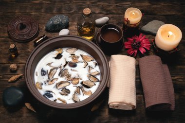 Aromaterapi konsepti geçmişi. Süt, tütsülenmiş bir kâse ve kahverengi ahşap bir masa üzerinde gerekli yağ..