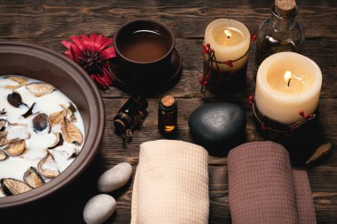 Aromaterapi konsepti geçmişi. Süt, tütsülenmiş bir kâse ve kahverengi ahşap bir masa üzerinde gerekli yağ..