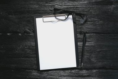 İş planı planı. Anket formu şablonu. Fotokopi alanı, gözlük ve siyah arka planda bir kalem olan boş beyaz kağıt sayfa.