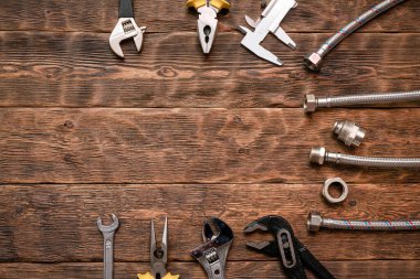 Fotokopi alanı olan düz arkaplan döşeme. Tesisatçı tezgahında çalışma araçları ve boru hattı parçaları.