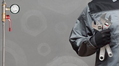 Tesisatçı kartviziti modeli. Gri arkaplan üzerinde ayarlanabilir anahtar ve kopyalama alanı olan işçi eli.