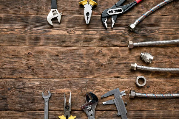 Fotokopi alanı olan düz arkaplan döşeme. Tesisatçı tezgahında çalışma araçları ve boru hattı parçaları.