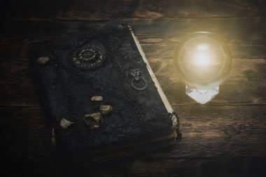 Kristal küre ve sihirli bir kitap Büyücü masasının arkasında.