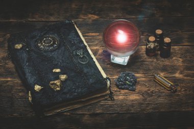 Kristal küre ve sihirli bir kitap Büyücü masasının arkasında.