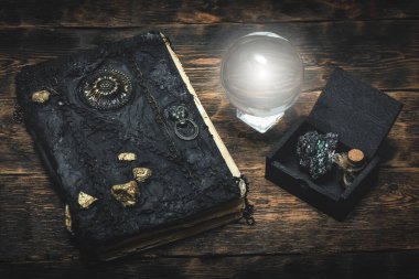 Kristal küre ve sihirli bir kitap Büyücü masasının arkasında.