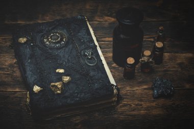 Büyücü masasında büyü kitabı, sihirli iksir ve diğer büyü aksesuarları.