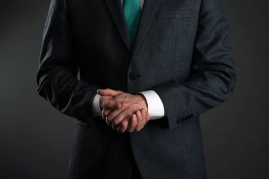 Gri arka planda çapraz kollu bir iş adamı. İş zekası. Sıkı patron..