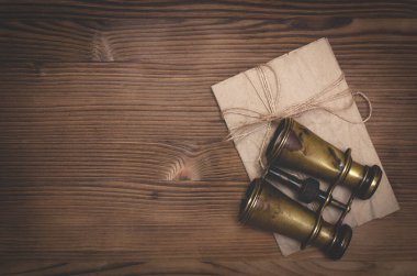 Seyahat ya da macera düz arkaplan bir kopya alanı ile yatıyordu. Dürbün ve eski mektup kahverengi ahşap bir masada..