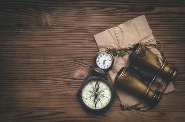 Seyahat ya da macera düz arka plan fotokopi alanı ile yatıyordu. Macera masası. Dürbün, zarfta mektup, pusula ve cep saati var..