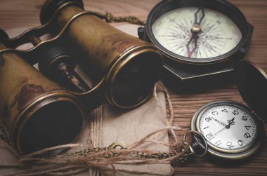 Seyahat ya da macera geçmişi. Macera masası. Dürbün, zarfta mektup, pusula ve cep saati var..