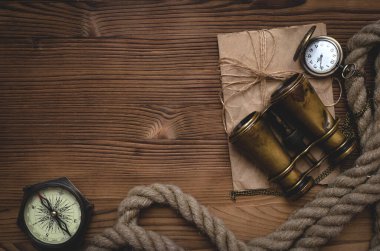 Seyahat ya da macera düz arka plan fotokopi alanı ile yatıyordu. Macera masası. Dürbün, parşömen, demirleme, pusula ve cep saati masanın üzerinde..