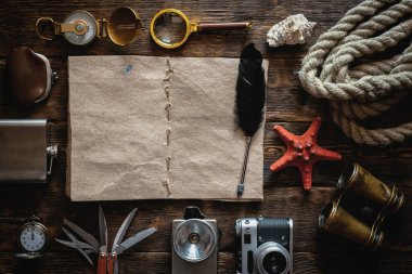 Maceracı ya da turist haritası. Gezginlerin günlüğü. Liste şablonu için kaşif. Tahta masa arkasında seyahat ve macera aksesuarları. 