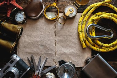 Maceracı ya da turist haritası. Gezginlerin günlüğü. Liste şablonu için kaşif. Tahta masa arkasında seyahat ve macera aksesuarları. 