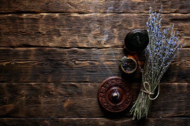 Kurutulmuş lavanta çiçeği dalları ve lavanta esaslı yağ şişeleri ahşap masa üzerinde fotokopi alanı ile birlikte. Bitkisel ilaç ya da aromaterapi konsepti.