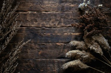 Kahverengi ahşap bir tahta üzerinde kurumuş otlar fotokopi alanı ile yatıyordu.. 