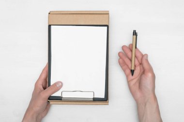 Teslimatçı çocuğun elinde bir karton kutu ve boş bir fatura belgesi beyaz tahta masa arka planında taklit ediliyor. Teslimat hizmeti kavramı.