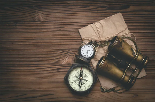 Seyahat ya da macera düz arka plan fotokopi alanı ile yatıyordu. Macera masası. Dürbün, zarfta mektup, pusula ve cep saati var..