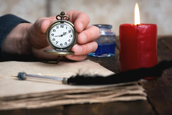 Uomo Tiene Mano Orologio Tasca Uno Sfondo Marrone Tavolo Con — Foto Stock