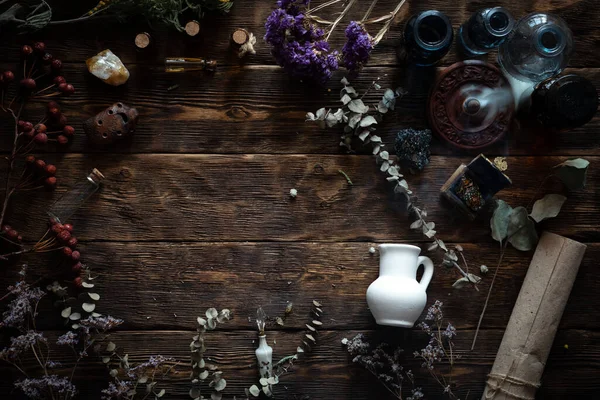 Kahverengi ahşap bir masada çeşitli kurutulmuş otlar ve şişeler. Bitkisel tıp, alternatif tıp konsepti veya büyücü doktor.