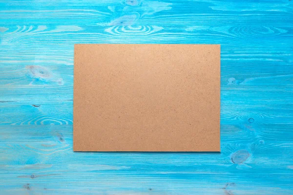 青いフラットレイアウトの背景に空白の段ボールページ — ストック写真