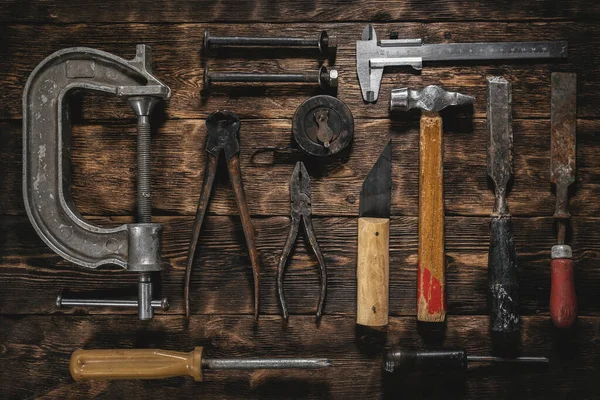 Old construction tools on a wooden workbench flat lay background. Carpenter table. Woodwork.