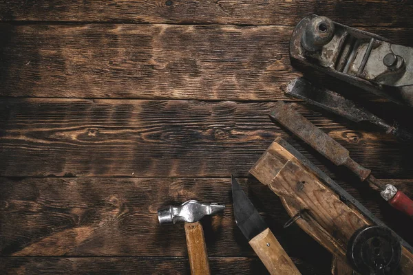Old construction tools on a wooden workbench flat lay background with copy space. Carpenter table. Woodwork.