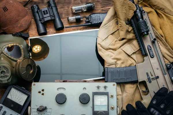 Post apocalypse soldier equipment on the table flat lay background.