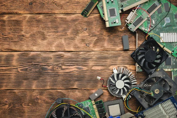 Old computer parts on a brown wooden table flat lay background with copy space.