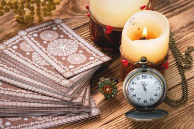 Kahverengi falcı masasında tarot kartları ve eski cep saati. Kehanet. Gelecek okuma zamanı kavramı.