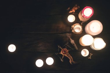 Ahşap masa zemininde mum yakan büyücü doktor aksesuarları. Büyücülük konsepti..