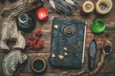 Sihir kitabı ve tahta masa arkasındaki diğer sihirli aksesuarlar. Büyücülük. Cadı doktor..