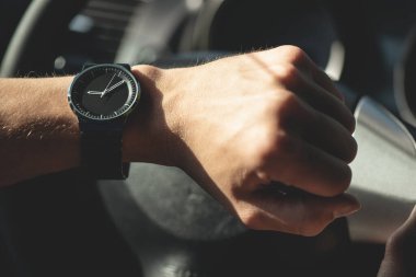 Sürücü kol saatine bakıyor. Yakından..