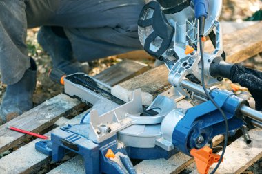 İşçi dairesel testere montajında odun kesiyor..