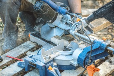 İşçi dairesel testereyle odun kesiyor..