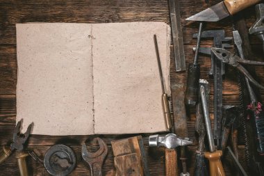 Marangozluk ya da inşaat ipuçları kitabı kopya alanı ve ahşap tezgah arka planındaki eski araçlar.