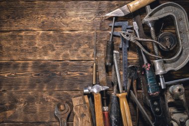 Kahverengi ahşap bir masa üzerinde eski marangozluk çalışma araçları fotokopi alanı ile düz zemin yatıyordu.