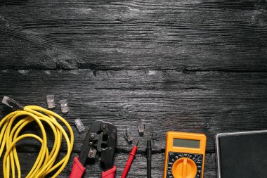 Bilgisayar ağı kurma kavramı. Crimper aracı, utp kablo, ağ anahtarı ve siyah ahşap masa üzerindeki konnektörler kopya alanı ile düz yatıyordu.