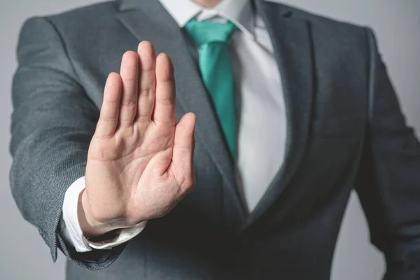 Businessman showing a stop gesture sign close up. Stop talking.