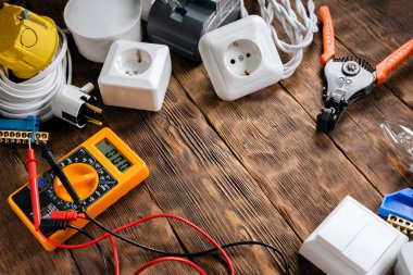 Elektriksel ekipman ve ahşap çalışma tezgahının arka planında kopyalama alanı olan çoklu metre.