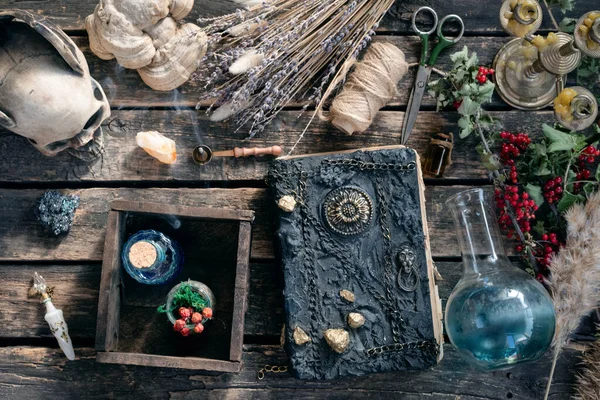 Spell book and magic potion on the old table. The witchcraft.