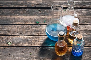 Renkli sihirli iksir şişeleri ahşap masa arkasında fotokopi alanı ile.