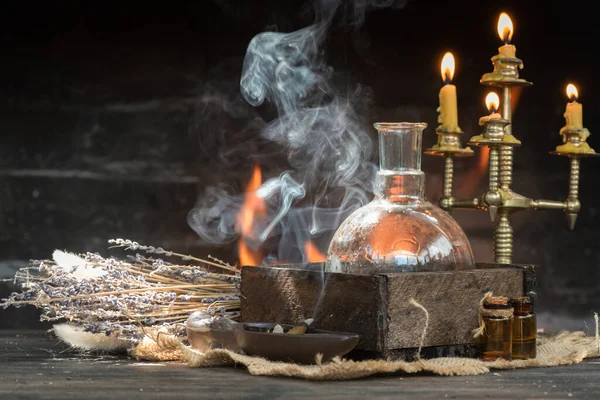 Magic potion on the table on burning fire in fireplace background. Alchemy concept.