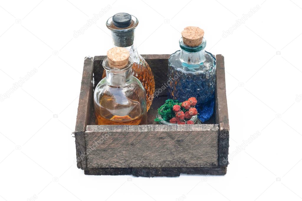 Magic potions in the bottles in wooden box isolated on the white background.